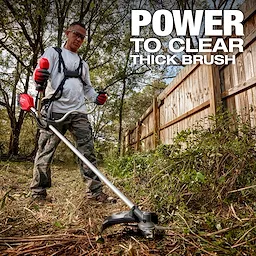A person using the M18 FUEL™ Brush Cutter to clear thick brush along a wooden fence line in a wooded area. Text on the image reads, "POWER TO CLEAR THICK BRUSH."