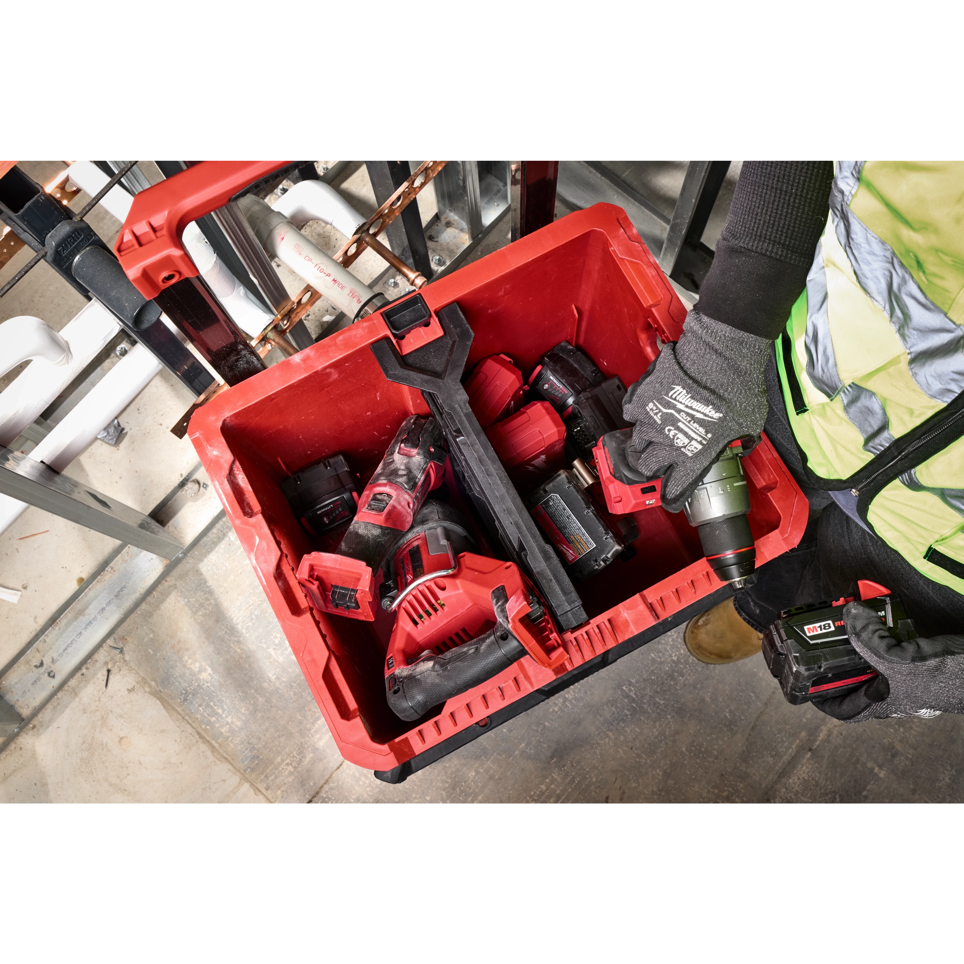 Divider for PACKOUT XL Crate inside a red storage box with various power tools and accessories, held by a person wearing gloves.