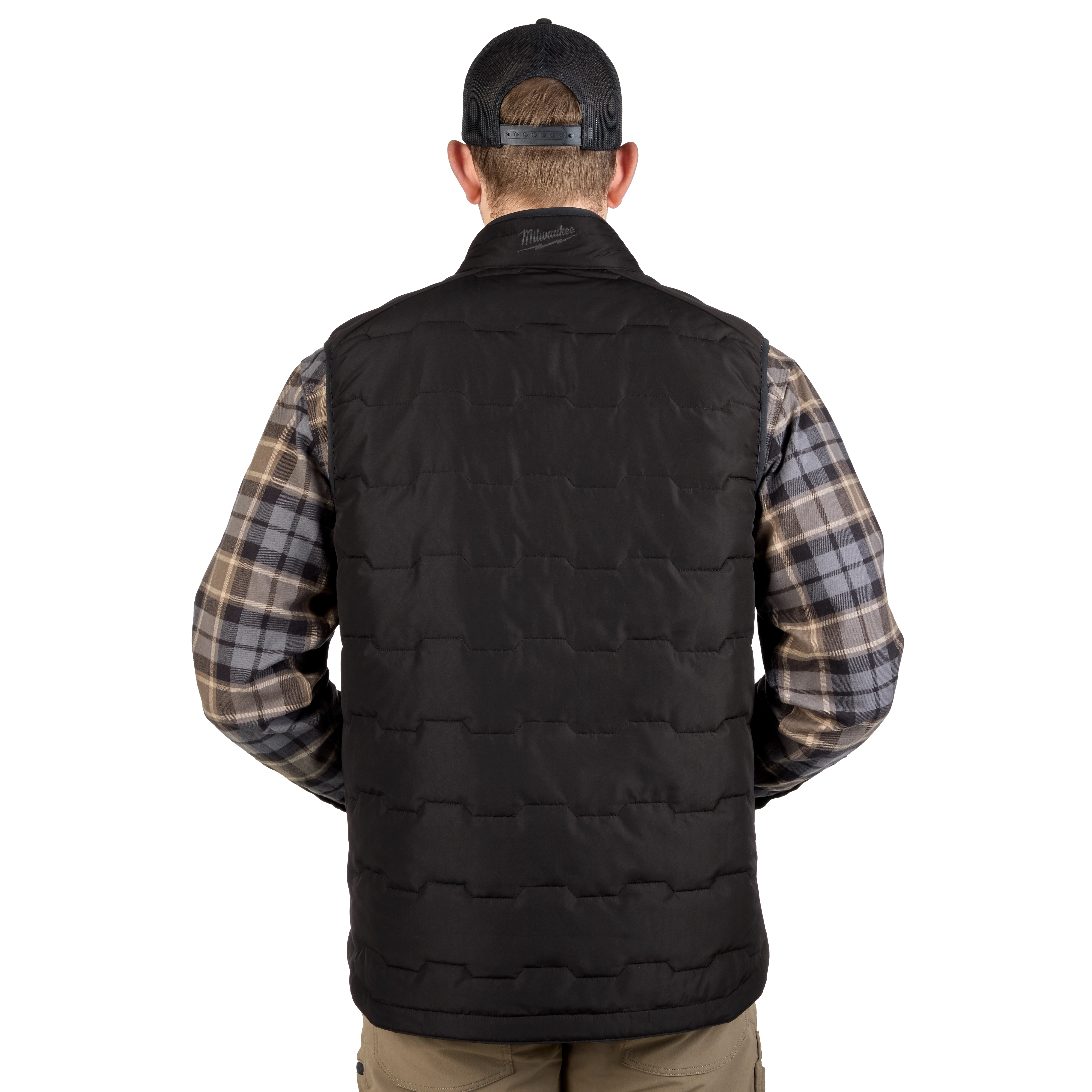 A man wearing a black FREEFLEX™ Lightweight Insulated Vest stands with his back facing the camera. He is also wearing a blue and gray plaid shirt with beige pants, and a black cap. The vest is quilted and appears warm and comfortable.