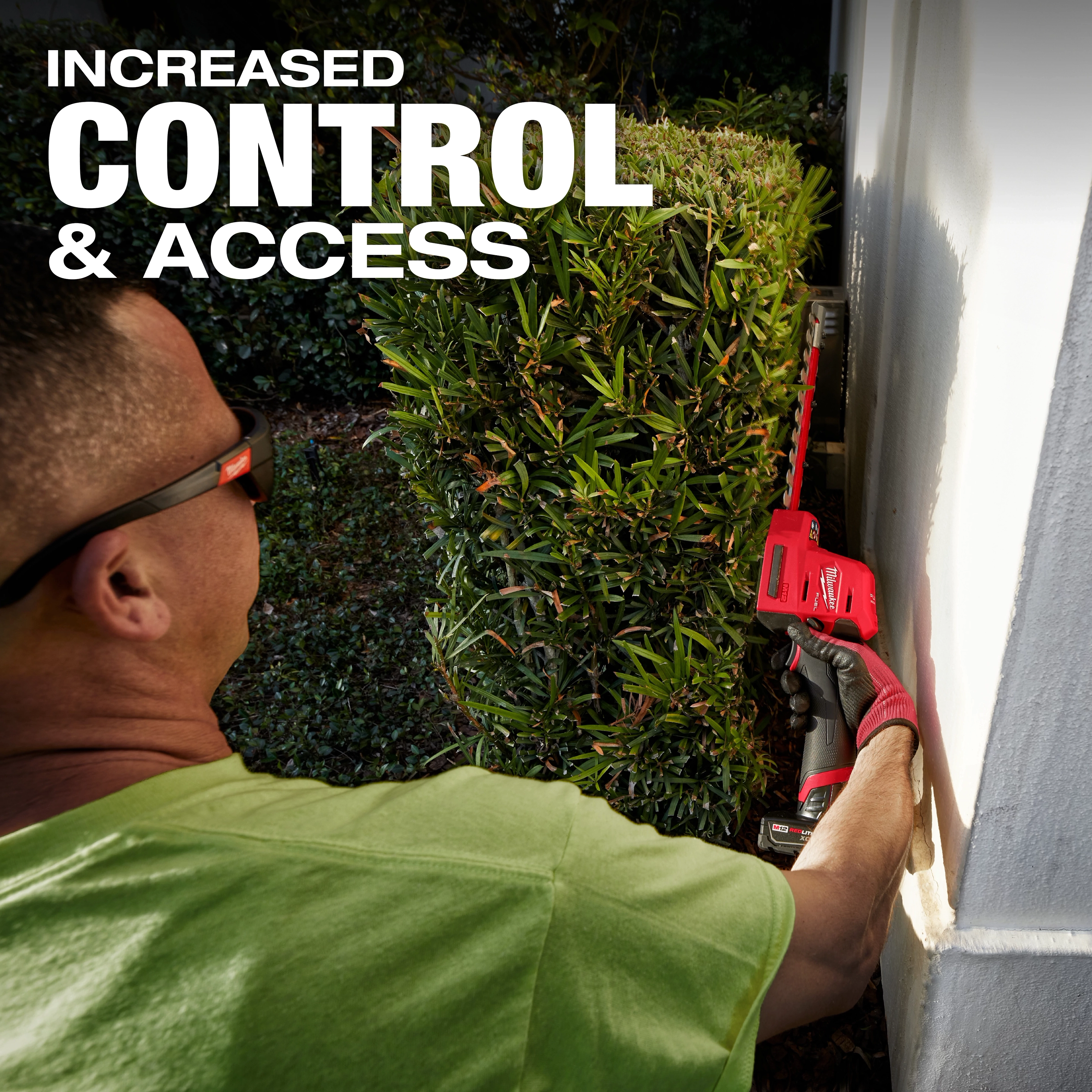 A person in a green shirt uses an M12 FUEL™ 8" Hedge Trimmer to trim a bush near a wall. The text "INCREASED CONTROL & ACCESS" is displayed at the top left.