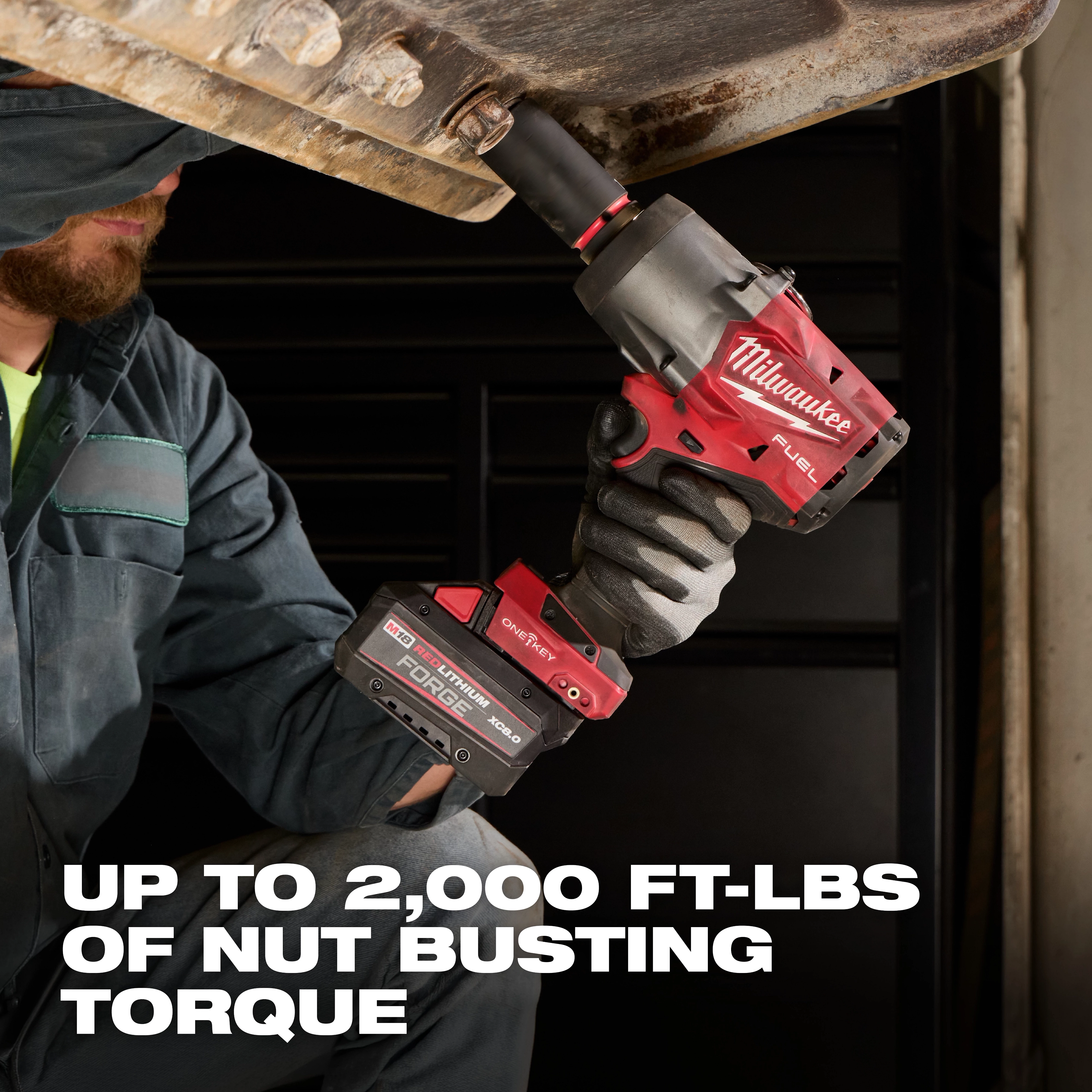 Worker using M18 FUEL 3/4" High Torque Impact Wrench w/ ONE-KEY Kit under a metal structure.