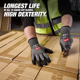 Hands wearing Cut Level 3 High Dexterity Nitrile Dipped Gloves w/ WEAR-DEFENSE Protection cutting cardboard boxes.