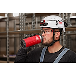 Image of a worker drinking from a Milwaukee PACKOUT Insulated Bottle with Chug Lid in black