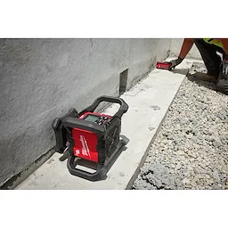 Worker using the Red Exterior Dual Slope Rotary Laser Receiver on concrete