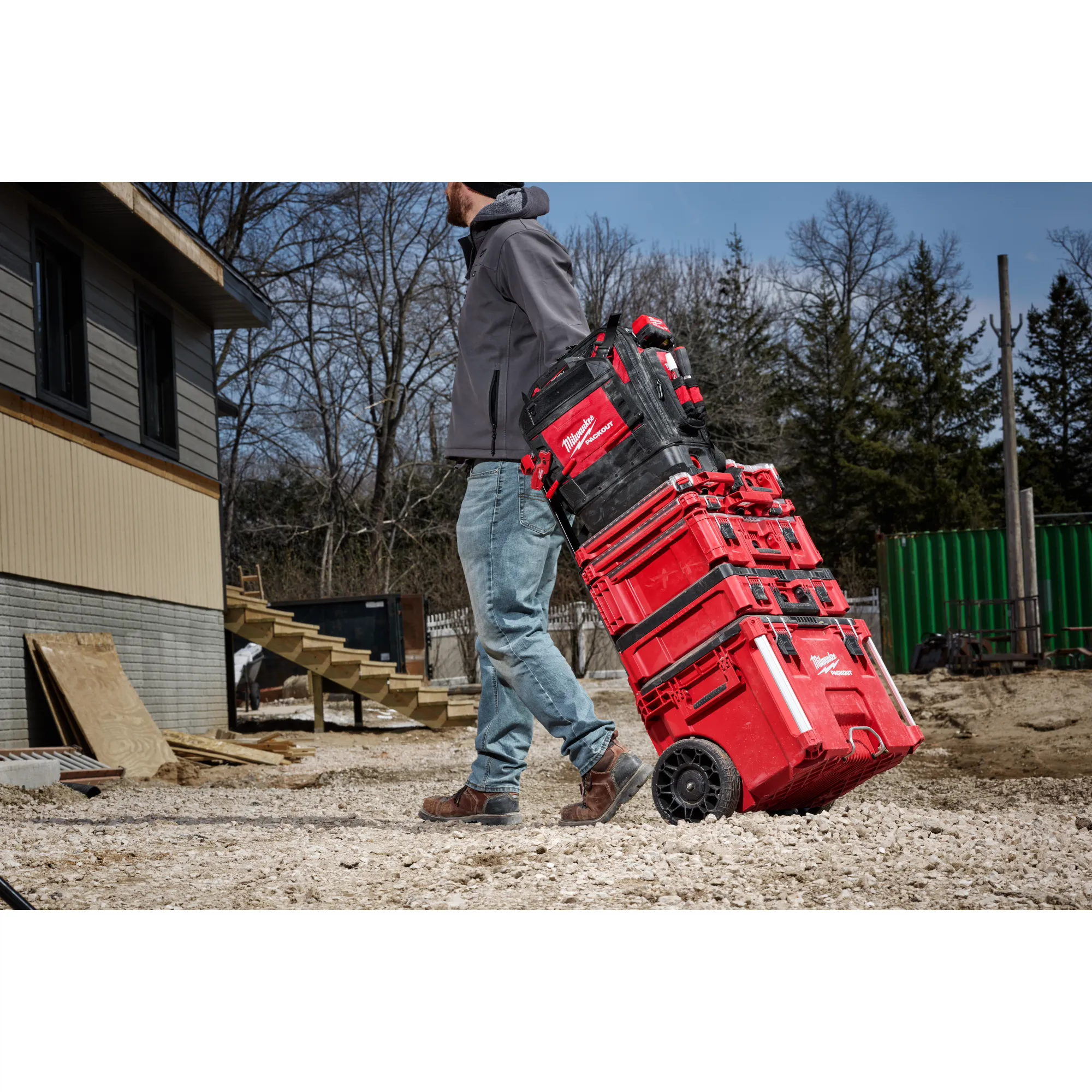 Image of the PACKOUT Rolling Toolbox being used by a worker on a jobsite highlighting the Low-Profile Handle feature