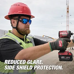 A construction worker wears Polarized Full Frame Safety Glasses with Removable Side Shields – Blue Mirrored Dual Coat Lenses, operating a power tool. The text, "Reduced Glare. Side Shield Protection." is displayed.