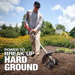 Person using an M18 FUEL QUIK-LOK Cultivator Attachment to till soil in a garden.