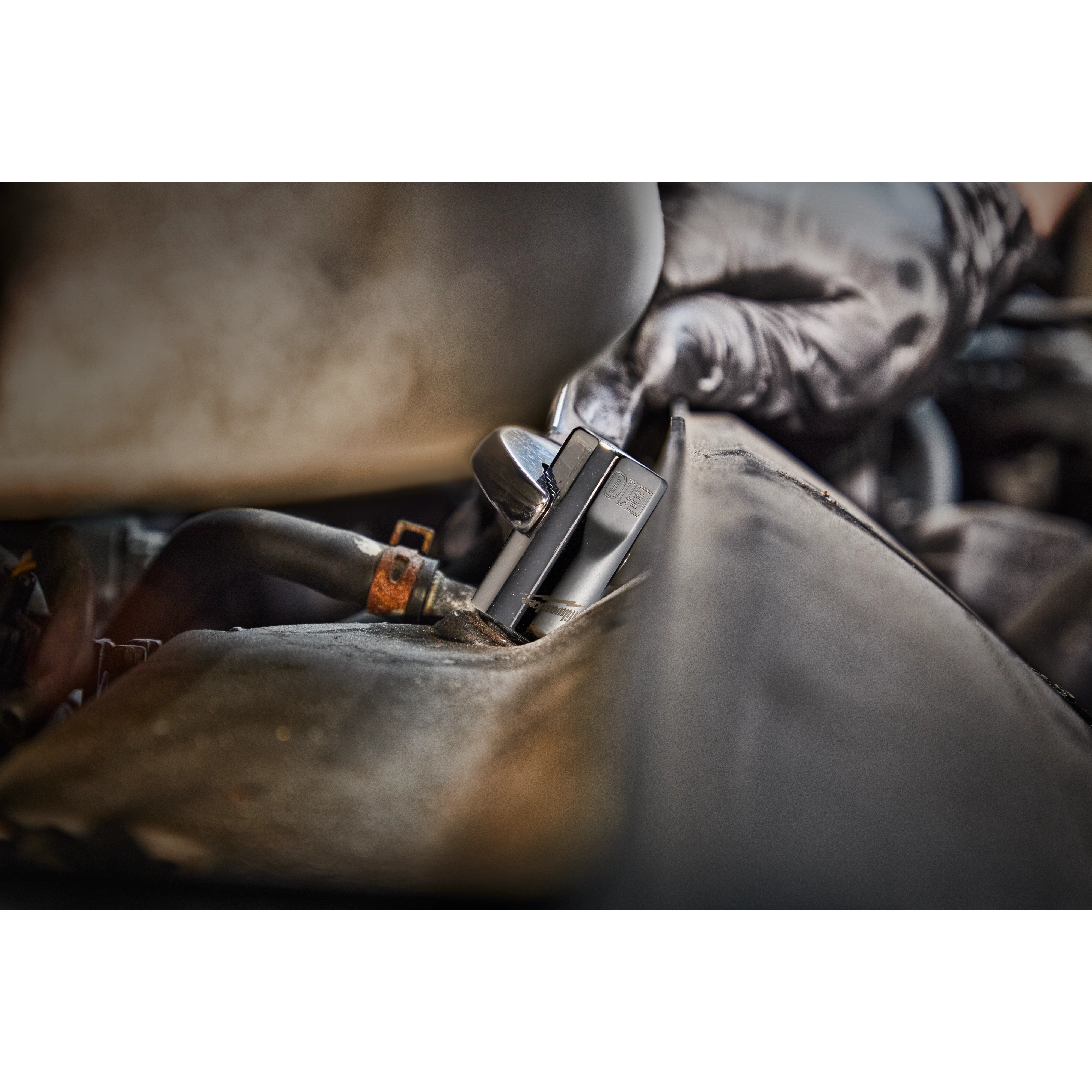A person wearing black gloves uses a tool to work on a car engine. The tool is part of a 12pc 1/4”, 3/8”, & 1/2” Drive External Torx Socket Set.