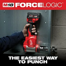A person uses the Milwaukee M18 FORCE LOGIC cordless knockout tool to punch a hole in a metal panel. The product is shown engaged in its application, demonstrating its ease of use. The image includes the slogan "The easiest way to punch."