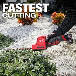 A person is using the M12 FUEL™ 8" Hedge Trimmer to trim a shrub in a garden. The text "FASTEST CUTTING" is prominently displayed at the top of the image. The hedge trimmer is red and black, labeled with the Milwaukee logo.