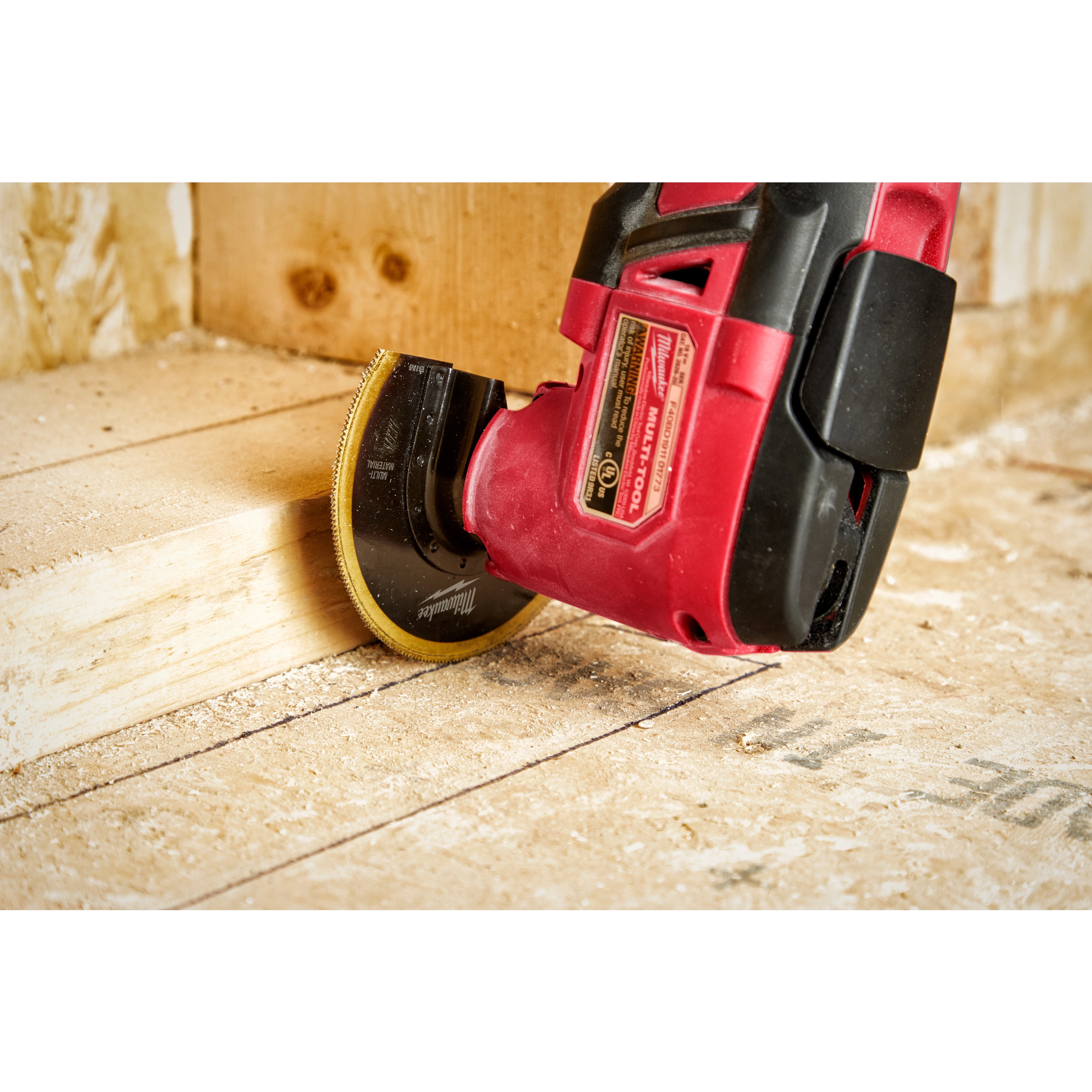 Milwaukee OMT Blades, 3-1/2" BIM TIN Segmented Blade, attached to a red power tool, is cutting through a wooden board.