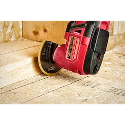 Milwaukee OMT Blades, 3-1/2" BIM TIN Segmented Blade, attached to a red power tool, is cutting through a wooden board.