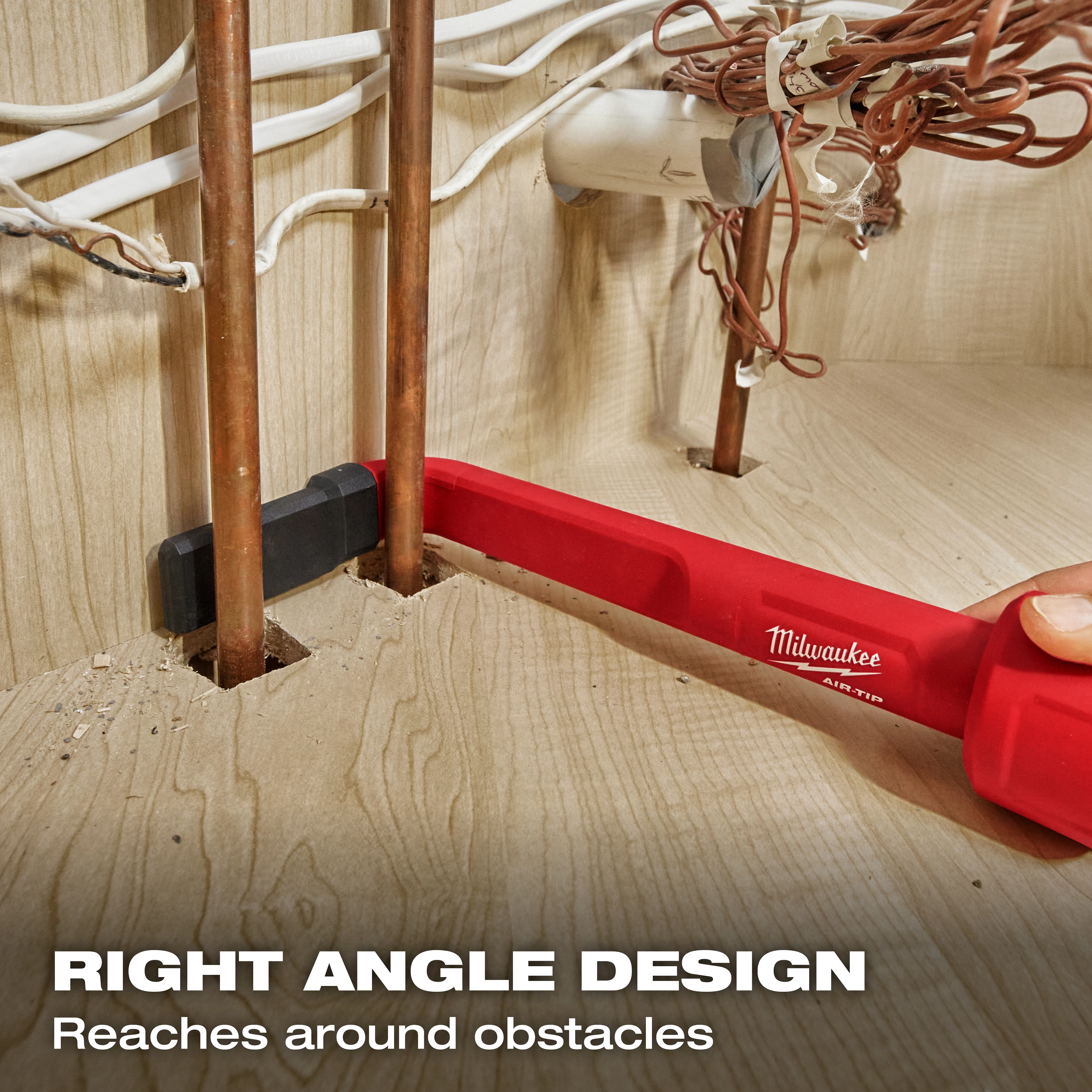 The image shows the AIR-TIP™ 4-in-1 Right Angle Cleaning Tool used to clean behind copper pipes and wires in a confined space. The tool is red and has a right angle design, allowing it to reach around obstacles. Text on the image reads, "RIGHT ANGLE DESIGN Reaches around obstacles."