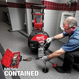 MX FUEL Sewer Drum Machine in use at a tiled floor maintenance site with a toolbox and various tools nearby. Text reads "MESS CONTAINED."