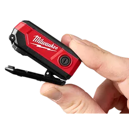 Milwaukee Rechargeable Clip Light held between two fingers. The compact, red, and black clip light features a power button.