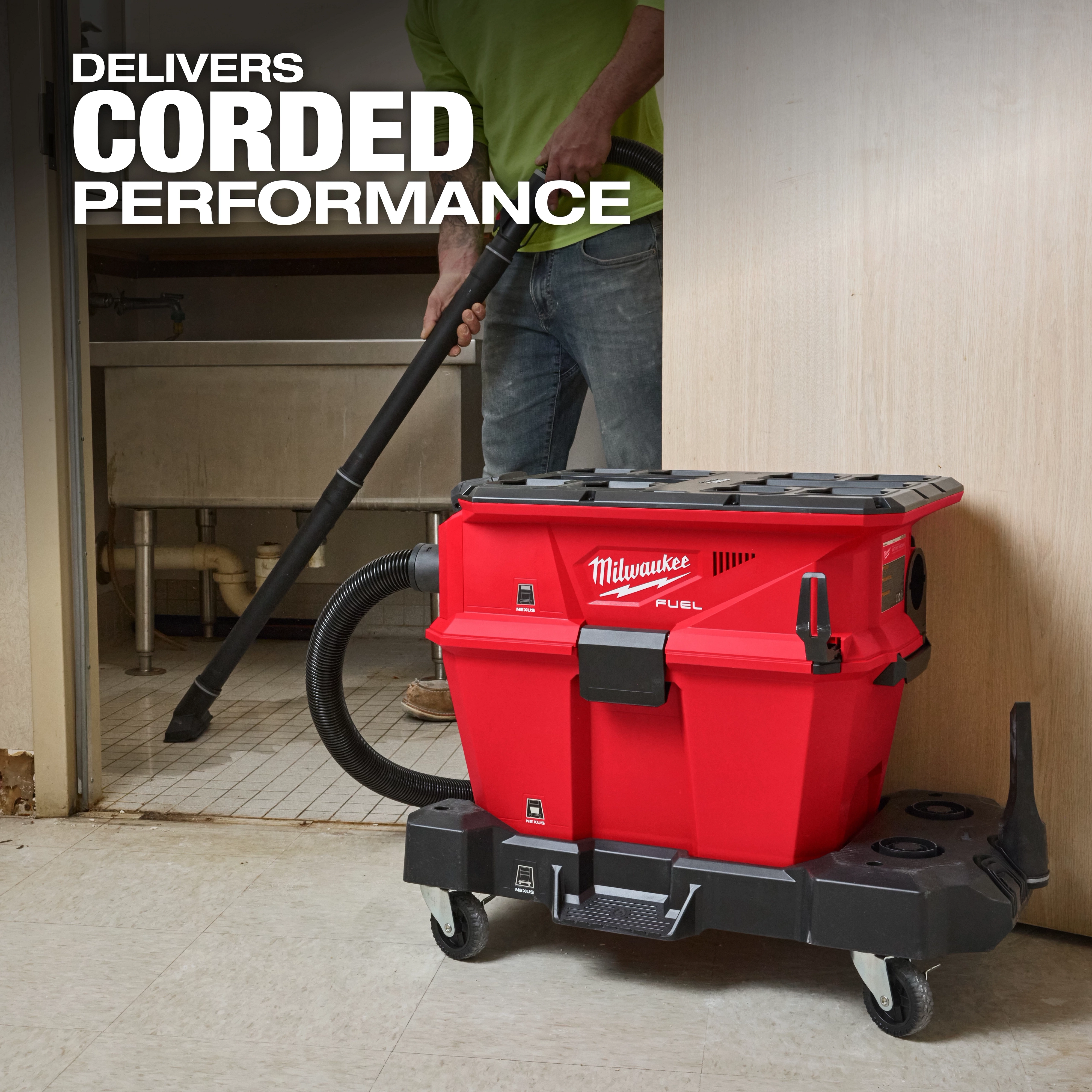 Milwaukee M18 FUEL™ NEXUS™ 6 Gallon Wet/Dry Vacuum w/ PACKOUT™ Compatibility & VACLINK™ is a red, portable vacuum cleaner on wheels, being used to clean a floor. The text "Delivers Corded Performance" is displayed in the upper-left corner.