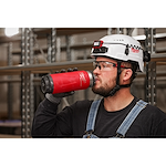 Image of a worker drinking from a Milwaukee PACKOUT Insulated Bottle with Chug Lid in red