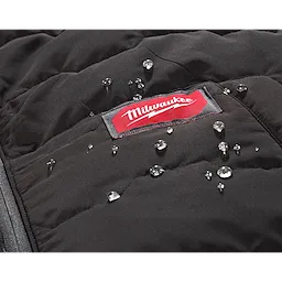 Close-up of the FREEFLEX™ Lightweight Insulated Vest showing water droplets on its black, stitched surface. The red and white Milwaukee logo is visible on the vest.