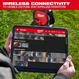 A person holds a tablet displaying Milwaukee's gallery app, showing time-stamped images and videos. A red Milwaukee wireless monitoring device is visible in the background on green grass. The top banner reads, "Wireless Connectivity to Mobile Devices and Wireless Monitors."