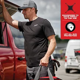 Man wearing black Hybrid Work Tee - Short Sleeve Feature Shot, standing by a red vehicle and holding a bag. Shirt provides UPF 50+ sun protection.