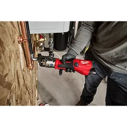 M12 FORCE LOGIC Press Tool Kit with ONE-KEY being used to press a fitting on a copper pipe by a person wearing work clothes.