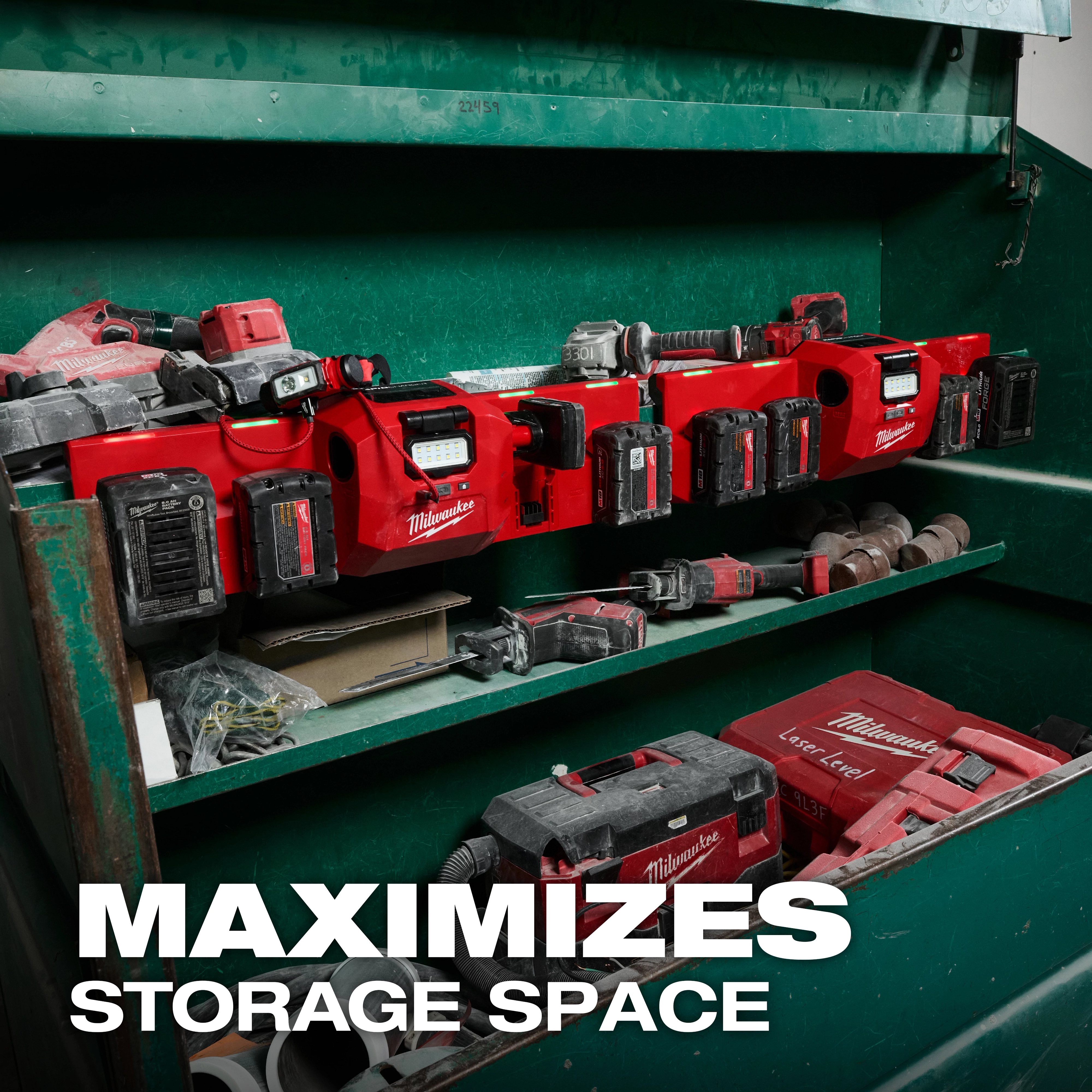 The M18™ and M12™ Gangbox Rapid Charger is mounted in a green storage cabinet, charging multiple Milwaukee batteries. Various tools and accessories are stored on adjacent shelves. The text "MAXIMIZES STORAGE SPACE" is displayed prominently on the image.