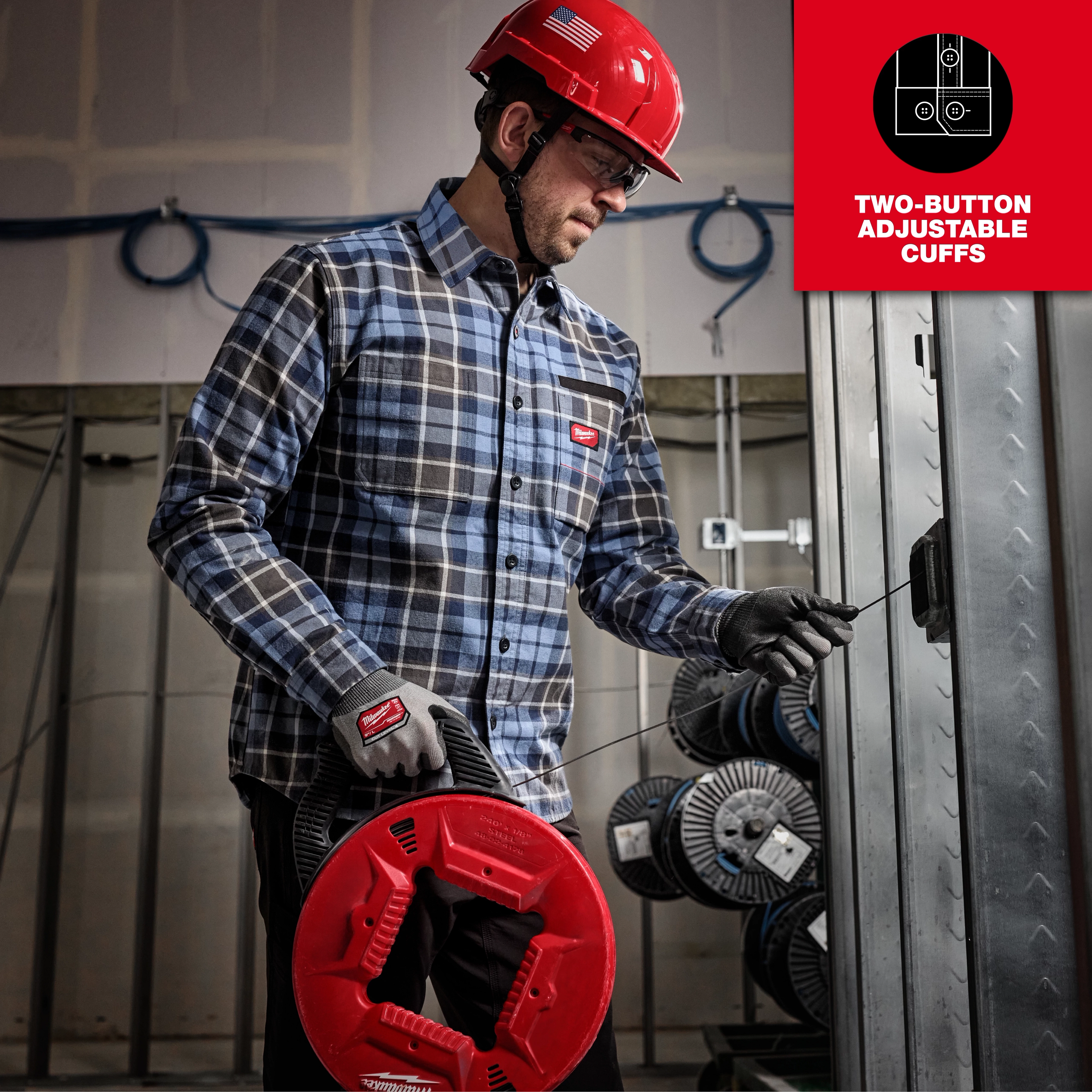 Man in a GRIDIRON Flannel Shirt working at a construction site. Features two-button adjustable cuffs in an industrial setting.