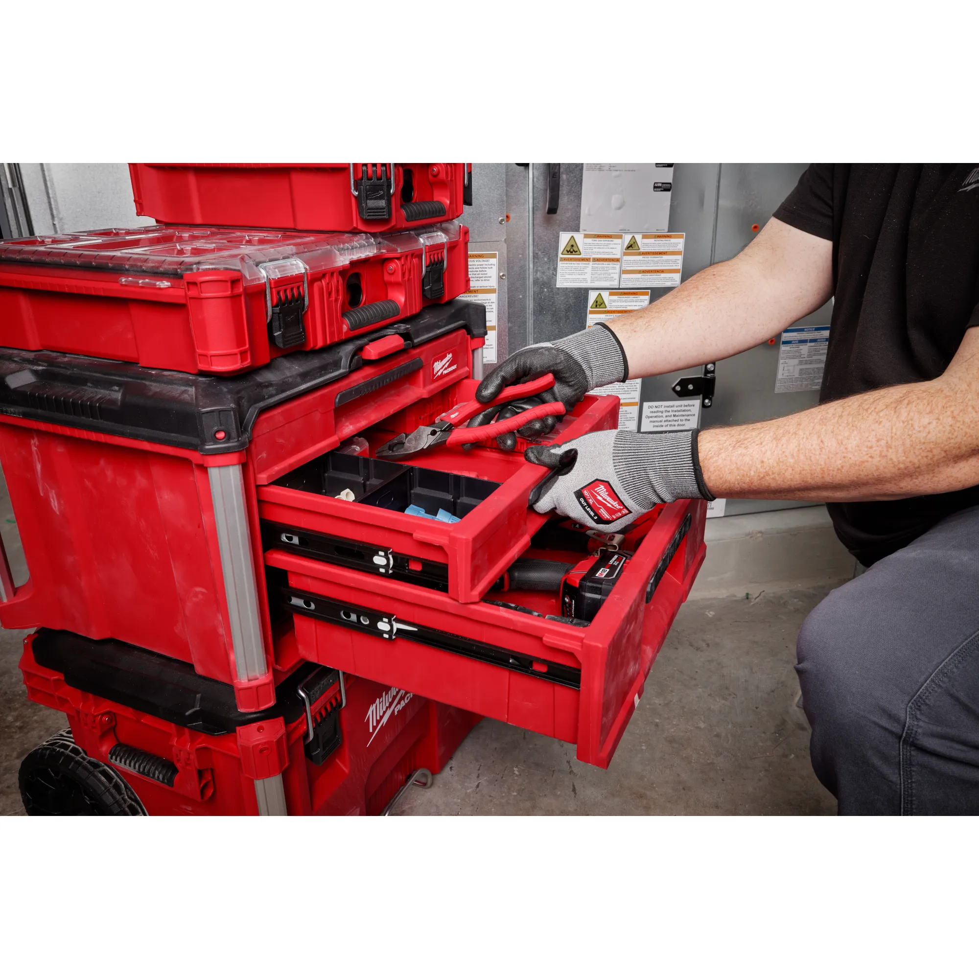 Worker utilizing the PACKOUT 3-Drawer Tool Box to store hand tools