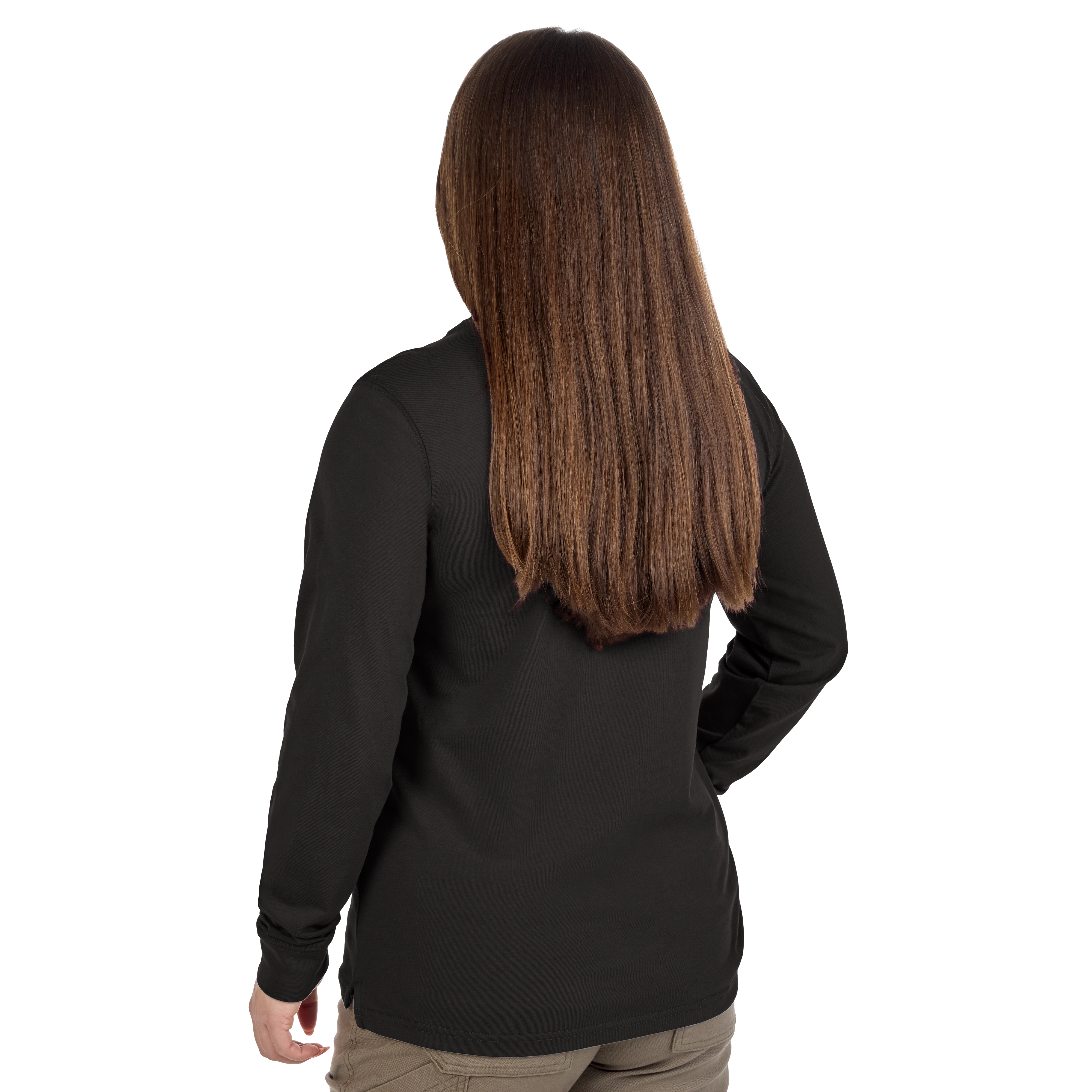 A woman with long, straight brown hair is seen from behind. She is wearing a black long-sleeve shirt and beige pants. She stands with one hand on her hip.