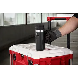 A person wearing a black glove places the PACKOUT 18oz Insulated Mug with Sip Lid on top of a red and white tool box.