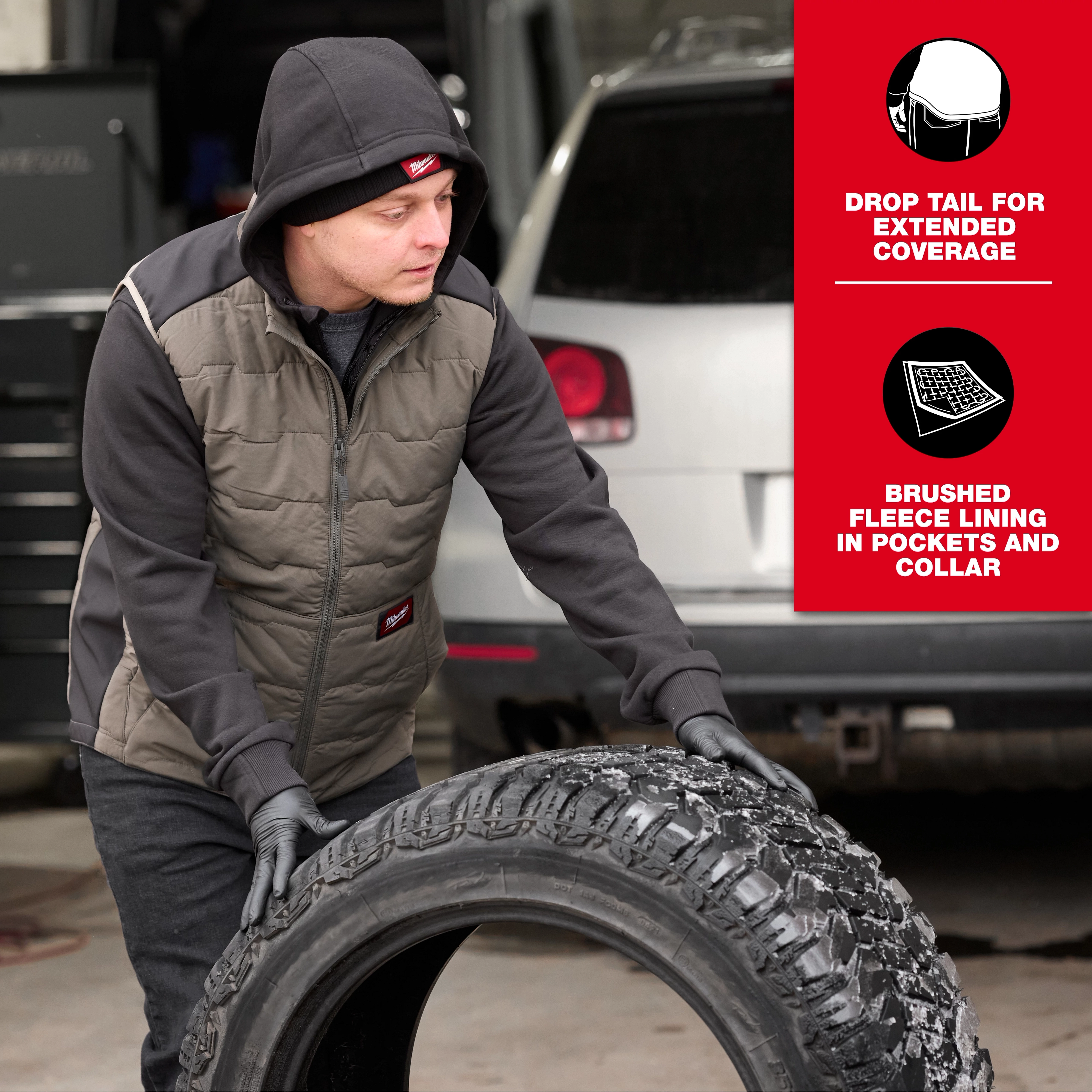 A person wearing the FREEFLEX™ Lightweight Insulated Vest in an outdoor setting rolls a large tire. The vest features drop tail for extended coverage and brushed fleece lining in pockets and collar.