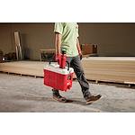 Image of a worker carrying a Milwaukee Cooler with a PACKOUT Insulated Bottle with Chug Lid in red