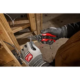 Worker using 8-20 AWG Dipped Grip Wire Stripper & Cutter (USA) on electrical wiring, wearing gloves and jacket.