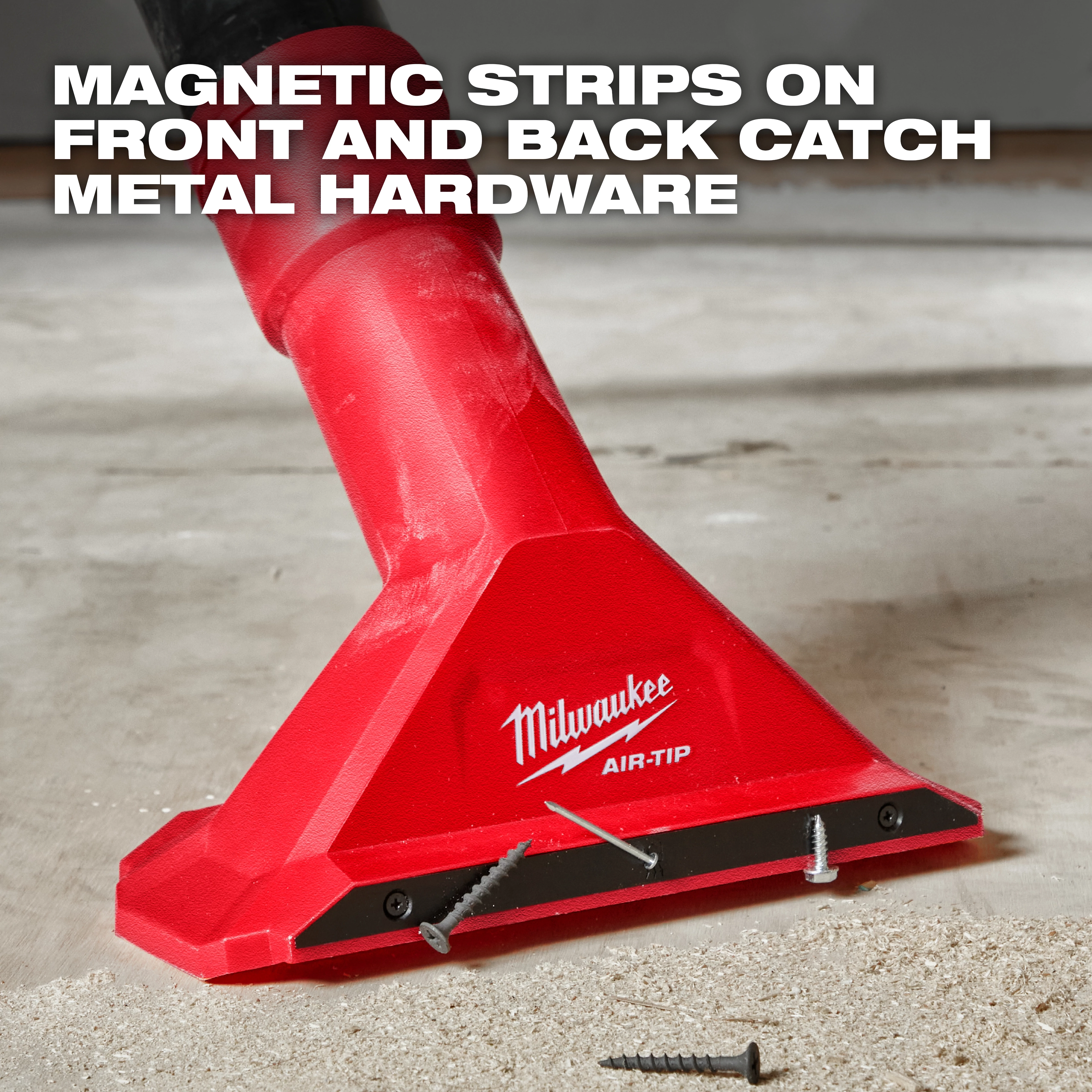 A red Milwaukee AIR-TIP™ 2 1/2" Magnetic Utility Nozzle is shown picking up screws from a floor. Text at the top states, "MAGNETIC STRIPS ON FRONT AND BACK CATCH METAL HARDWARE." The nozzle is attached to a vacuum cleaner and has screws adhered to its magnetic strip.