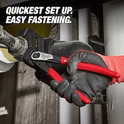 A gloved hand uses the Milwaukee Pliers Wrench with red handles to grip a pipe. Text overlay reads, "Quickest set up. Easy fastening."