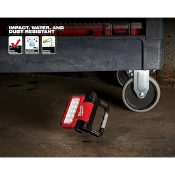 REDLITHIUM USB ROVER Pivoting Flood Light is shown under a tool cart, highlighting its impact, water, and chemical resistance.