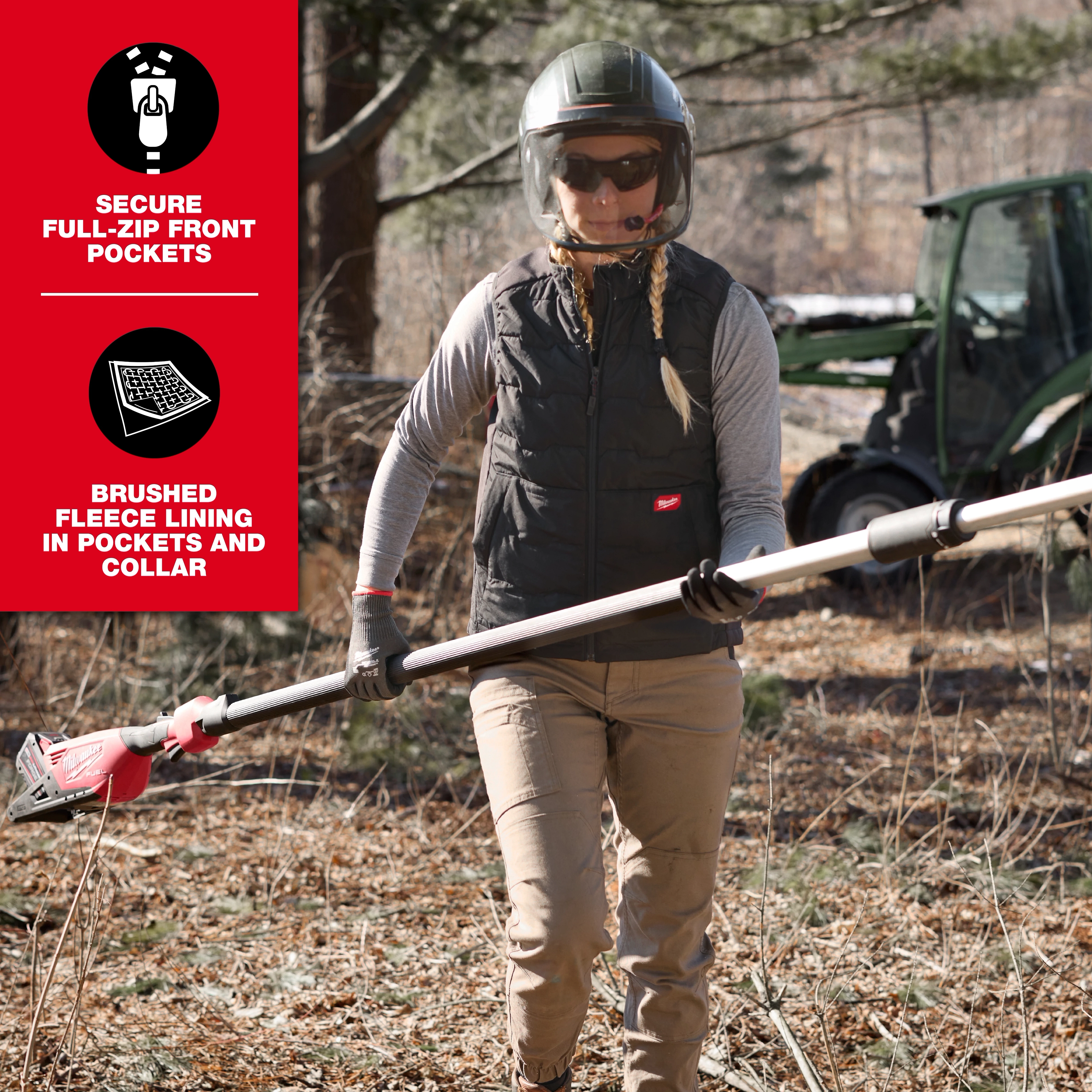 A person stands outside holding a power tool, wearing the Women's FREEFLEX™ Lightweight Insulated Vest in Black. The vest features secure full-zip front pockets and brushed fleece lining in pockets and collar. A tractor is visible in the background.