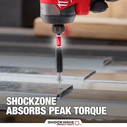 The image shows the SHOCKWAVE™ SHOCKZONE™ Bit Holder being used to drill a screw into metal, with the text "SHOCKZONE™ Absorbs Peak Torque" displayed. The product absorbs torque to prevent bit breakage during drilling.