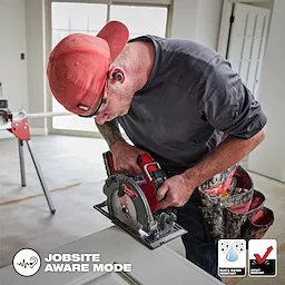 Worker on the jobsite wearing the Bluetooth ear buds while using a Milwaukee circular saw