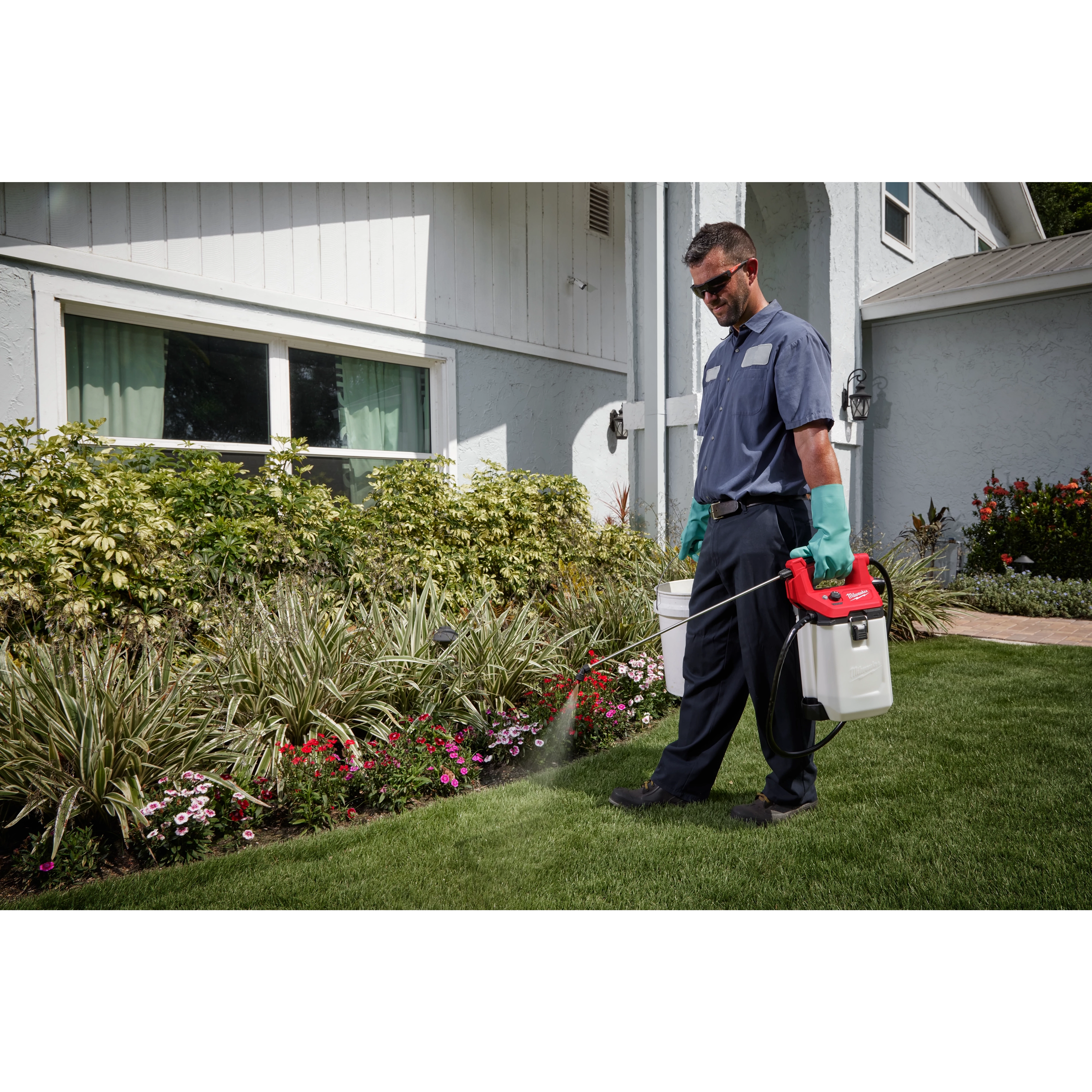 Man using the M12 Handheld Sprayer on bushes