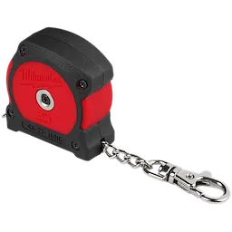 The image shows a Milwaukee Pipe Diameter Tape Measure. It has a black and red plastic casing, a retractable metal chain, and a keychain clip attached at the end. The tape measure is compact and designed to measure pipe diameters accurately.