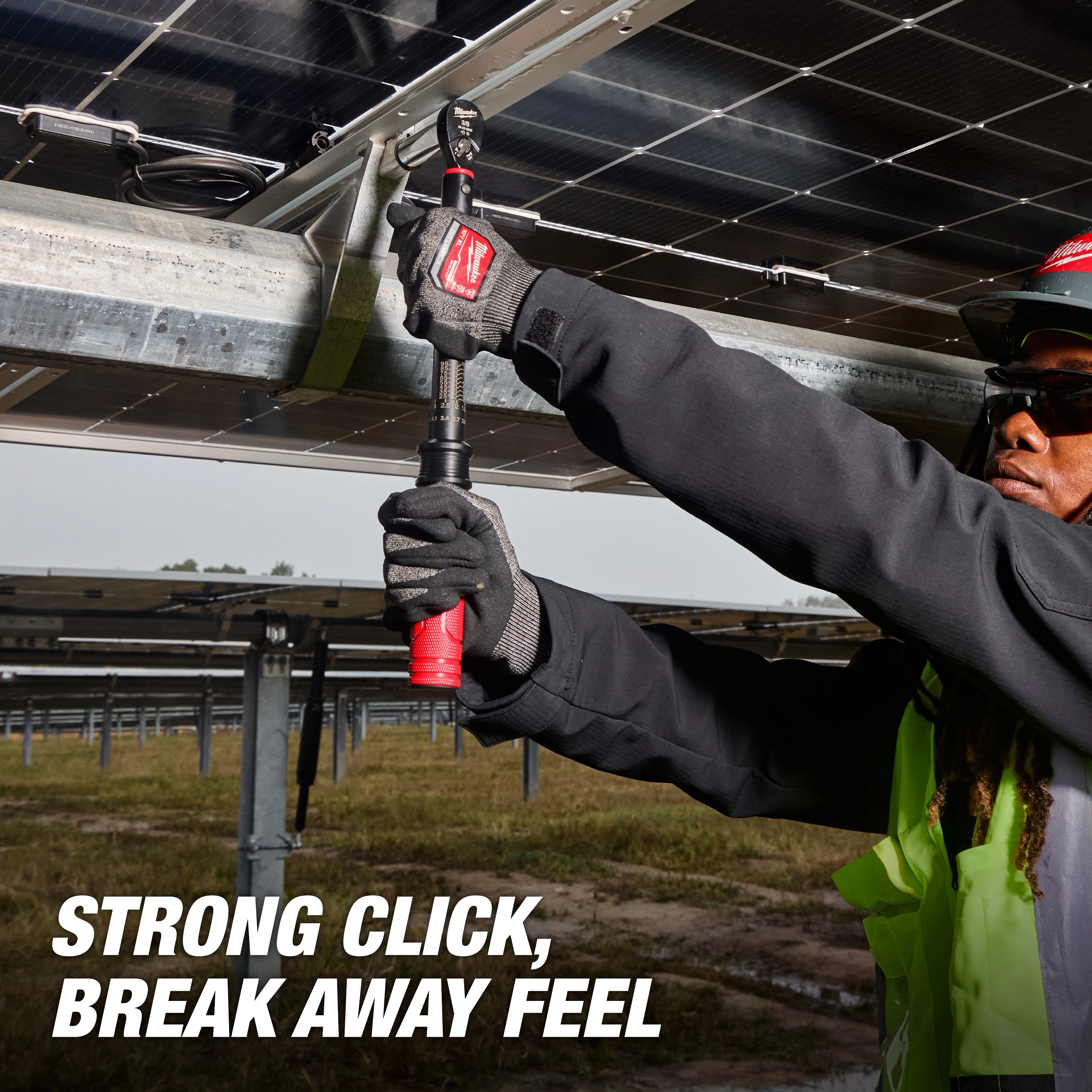 Worker using a 3/8” Drive Click Torque Wrench (20-100 ft·lbf) on metal structures with solar panels, text reads "STRONG CLICK, BREAK AWAY FEEL."