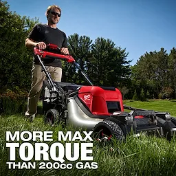 A person uses the M18 FUEL™ 21" Self-Propelled Dual Battery Mower on a grassy lawn with trees in the background. The text on the image reads "MORE MAX TORQUE THAN 200cc GAS".